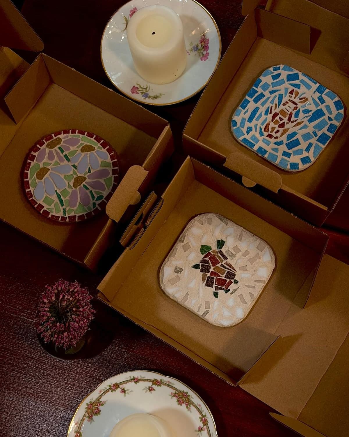 Des dessous de verre en mosaïque dans leur boîte kraft, prêts à offrir