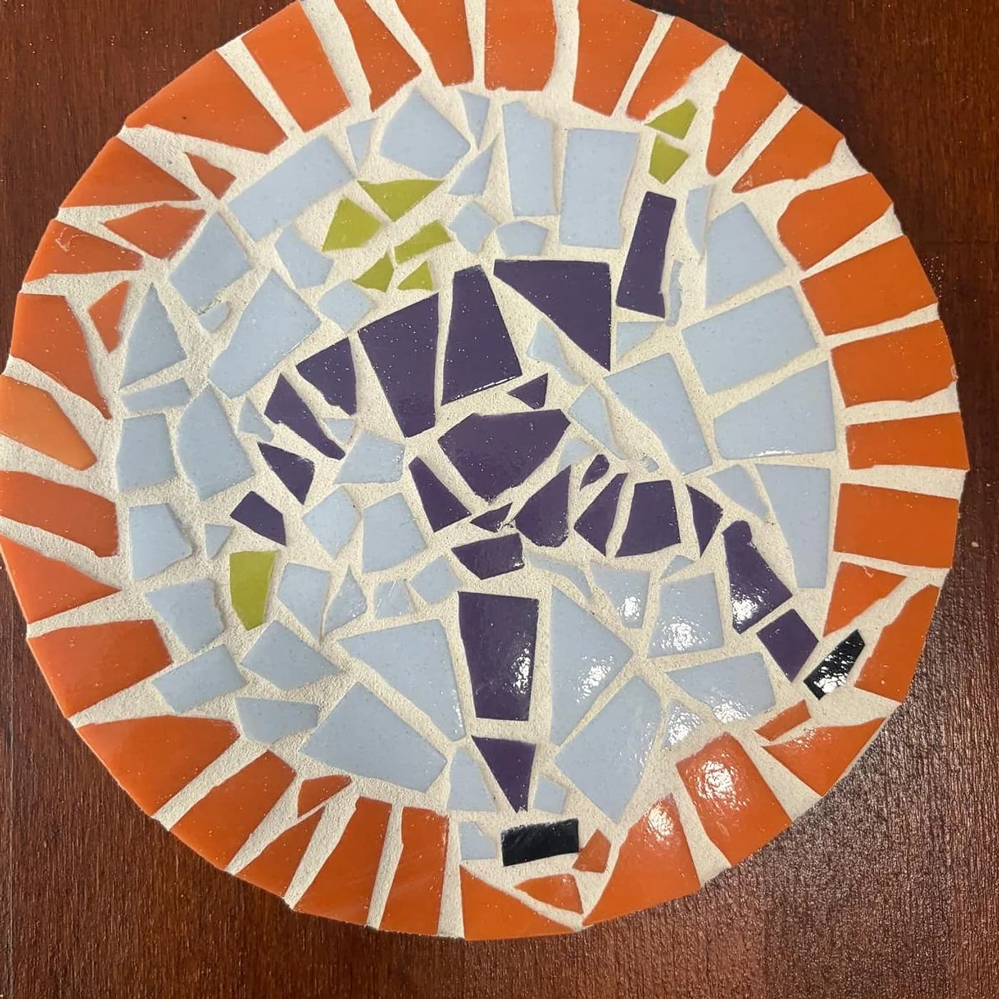 Dessous de plat rond, orange et violet, mosaïque réalisée chez Artichaut à Montmartre